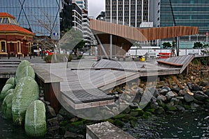 Modern North Kumutoto Pavilion with strips on folded plates and steel posts on coastal decked square, Wellington CBD, New Zealand