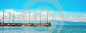 North macedonia. Ohrid. Long pier with different sailboats and mountines on background photo