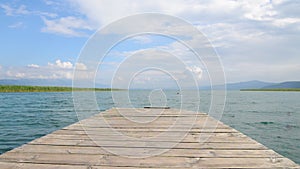 North macedonia. Ohrid. Wood pier in Ohrid lake in sunny day with reeds, pier and mountaines on background.