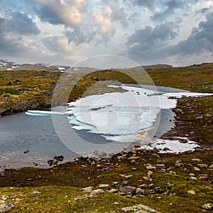 North Norway mountain spring tundra valley and puddle with ice cake