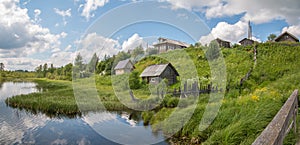 North Russian village. Summer day, river, old cottages on coast. photo