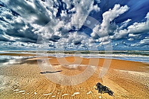 The north sea beach with clouds and  sun , wide angle view of the nordsea