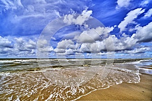 The north sea beach with clouds and sun , wide angle view of the nordsea