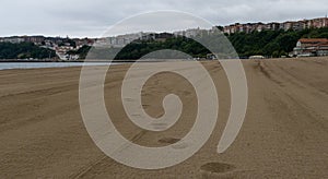 North sea beach with cloudy day with waves on the shore and village