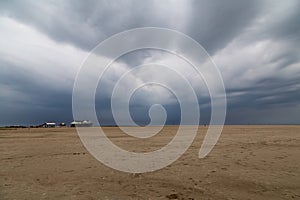 North sea dike landscape with dramatic sky and stilt house