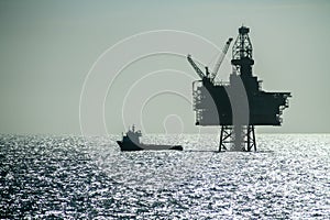 Silhouette of an Offshore Supply Vessel alongside oil platform Ringhorn in the North Sea photo