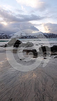 Rocks on Ramsberg beach on Flakstad island on the Lofoten islands in winter at sunset photo