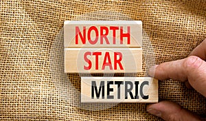 North star metric symbol. Concept words North star metric on wooden blocks on a beautiful canvas table canvas background.