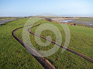 NORTHAM, NORTH DEVON, ENGLAND - JANUARY 29 2021: Car tyre tracks on the grass, mud at Northam Burrows coastal reserve.