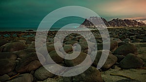 The norther lighfs over the cloud on a beach full of rocks