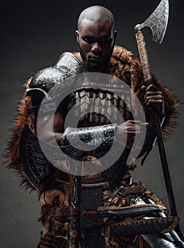 Northern african chief with fur wielding dual axes in dark background