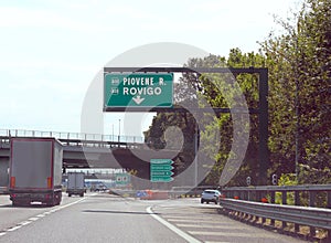 Northern Italian motorway junction with signs for the cities of Rovigo and Piovene and trucks photo