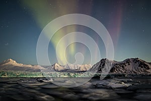 Northern Lights above the Arctic glacier and mountains - Svalbard, Spitsbergen