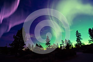 Northern lights aurora borealis in the night sky over beautiful lake landscape photo