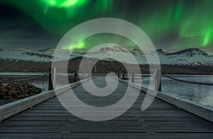 Northern lights/ Aurora borealis over snow covered mountains in Faskrudsfjordur in Iceland.