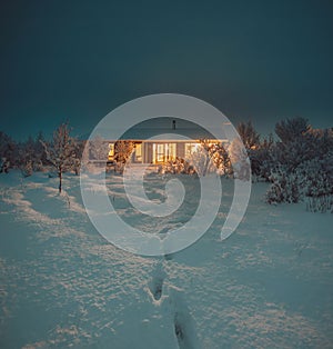 Northern Lights and Aurora Borealis over Winter landscape with wooden house under a beautiful starry sky and in Iceland.