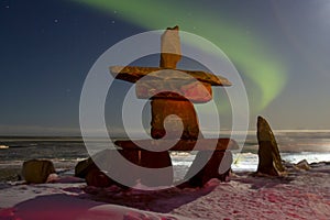 Northern lights and inukshuk on Hudson Bay at night