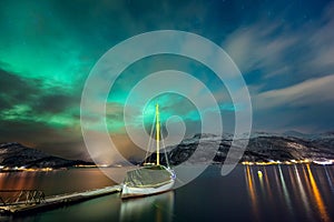 Northern lights in the Norwegian fjord and the yacht