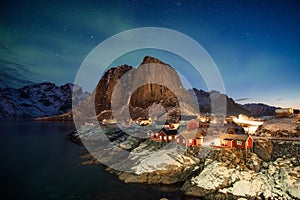 Northern lights over mountain in fishing village at Hamnoy