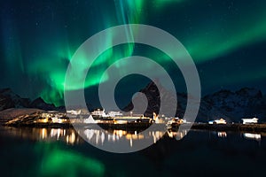 Northern lights over the mountain at sakrisoy rorbuer in winter season, Lofoten islands, Norway