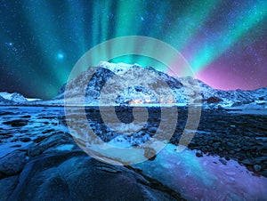 Northern lights over the mountain, sea coast, city lights