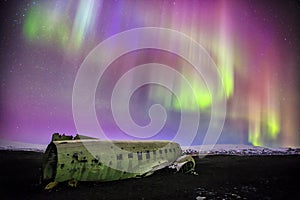 Northern lights over plane wreck in Vik, Iceland photo