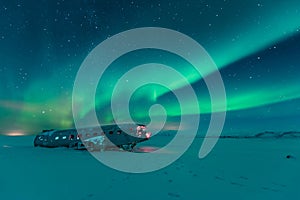 Northern lights over plane wreck on the wreck beach in Vik, Iceland photo