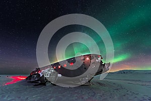 Northern lights over plane wreck on the wreck beach in Vik, Iceland