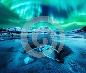 Northern lights over snowy mountains, frozen sea coast