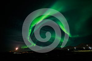 Northern lights and the rising Moon nearby Nuuk city