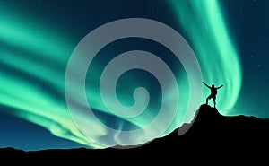 Northern lights and silhouette of standing happy man. Aurora