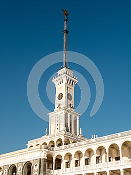 Northern River Station. Spire with a star on the roof of the building against the blue sky. Side view. Close-up, vertical