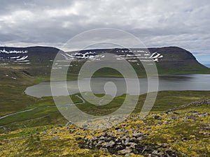 Northern summer landscape, beautiful snow covered cliffs and fljotsvatn lake in Fljotavik cove in Hornstrandir, west photo