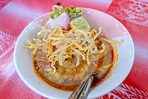 Northern Thai Cuisine with spicy curry soup topping with Lemon, Pickled, Lettuce