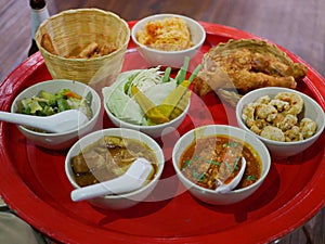 Northern Thai customary style dinner khantoke with variety of local menus being served family-style on large platters photo