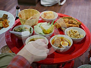 Northern Thai customary style dinner khantoke with variety of local menus being served family-style on large platters photo