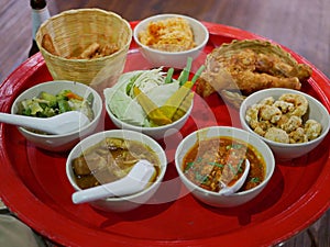 Northern Thai customary style dinner khantoke with variety of local menus being served family-style on large platters