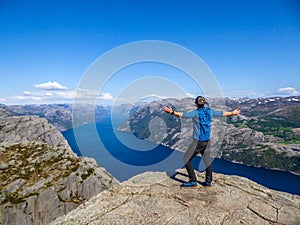 Norway - Boy standing on a steep cliff with the view on Lysefjorden