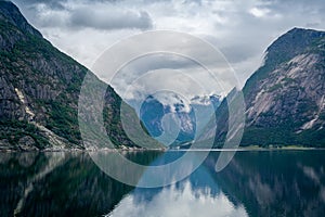 Norway fjord scenic landscape of Eidfjord with mountain reflections on the water.