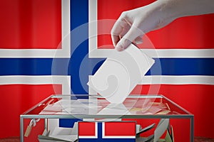 Norway flag, hand dropping ballot card into a box - voting, election concept