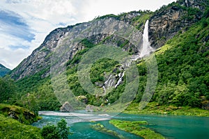 Norway landscape with waterfall in mountain river canyon.