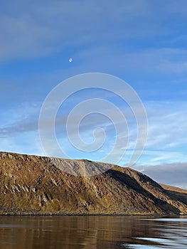 Full moon above the mountains and water in the fjords in Norway