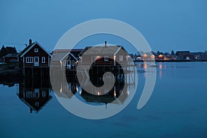 Norway rorbu houses and mountains rocks over fjord landscape scandinavian travel view Lofoten islands. Night landscape.