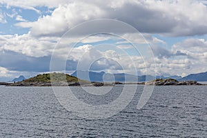 Norwegian fjord and mountains surrounded by clouds, ideal fjord reflection in clear water. selective focus