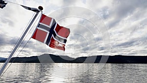 Norwegian flag on boat in the Osterfjord near Bergen in Norway in Autumn