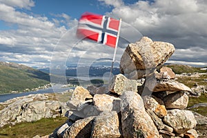 Norwegian flag in the wind at mountains top
