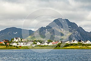 Norwegian houses and cottages at the lake with mountain in the background, Leknes, Vestvagoy Municipality, Nordland county, Norway