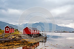 Norwegian hut rorbu on bay coast. Nordic cloudy summer day.