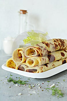 Norwegian potato pancakes Lefse on a light background with cheese and greens.