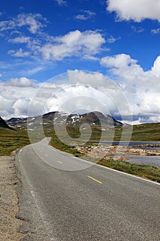 Road mountain landscape blue sky summer travel Norway vertical empty highway nature asphalt green beautiful rural way country trip photo